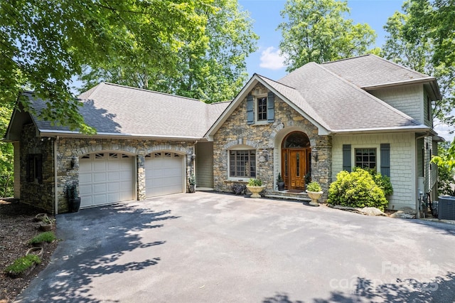 102 Coyote Rdg, Maggie Valley, NC 28751 - view of front of home featuring stone siding, driveway, a garage, and roof with shingles