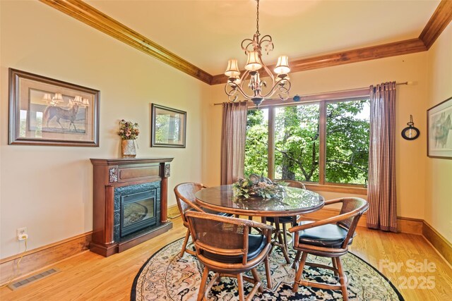 102 Coyote Rdg, Maggie Valley, NC 28751 - dining space featuring crown molding, a chandelier, a high end fireplace, light wood finished floors, and baseboards