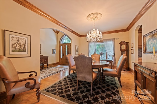 102 Coyote Rdg, Maggie Valley, NC 28751 - dining space with arched walkways, ornamental molding, a chandelier, and light wood-style flooring
