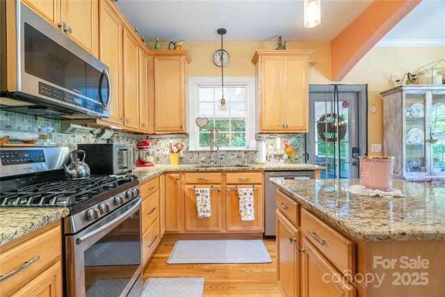 333 Garden Valley Dr, Winston Salem, NC 27107 - kitchen with stainless steel appliances, tasteful backsplash, light wood finished floors, light stone counters, and hanging light fixtures