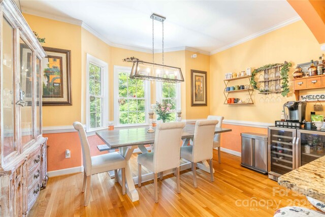 333 Garden Valley Dr, Winston Salem, NC 27107 - dining room featuring wine cooler, light wood-style flooring, a chandelier, and crown molding