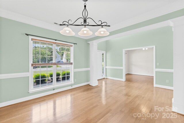 112 Doyle Farm Ln, Mooresville, NC 28115 - unfurnished dining area featuring a chandelier, wood finished floors, ornamental molding, baseboards, and ornate columns
