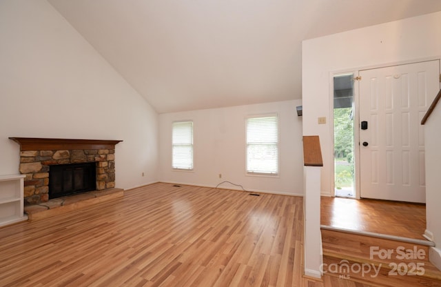 3221 5th Street Ct NW, Hickory, NC 28601 - unfurnished living room featuring light wood finished floors, vaulted ceiling, and a stone fireplace