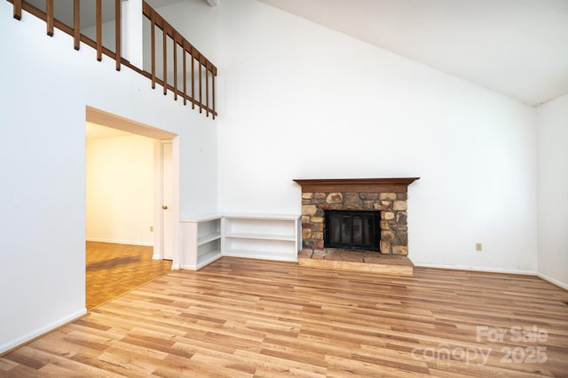3221 5th Street Ct NW, Hickory, NC 28601 - unfurnished living room featuring light wood-style floors, high vaulted ceiling, baseboards, and a stone fireplace