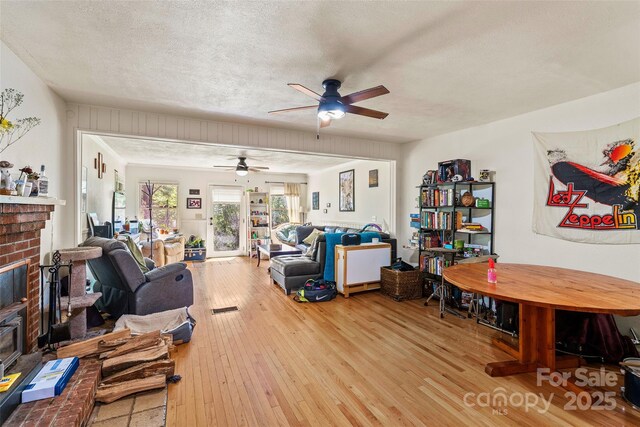 14 Luckenbach Dr, Fairview, NC 28730 - living area featuring ceiling fan, a fireplace, wood-type flooring, and a textured ceiling