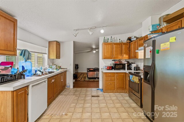 14 Luckenbach Dr, Fairview, NC 28730 - kitchen featuring stainless steel appliances, a textured ceiling, light countertops, brown cabinetry, and a ceiling fan
