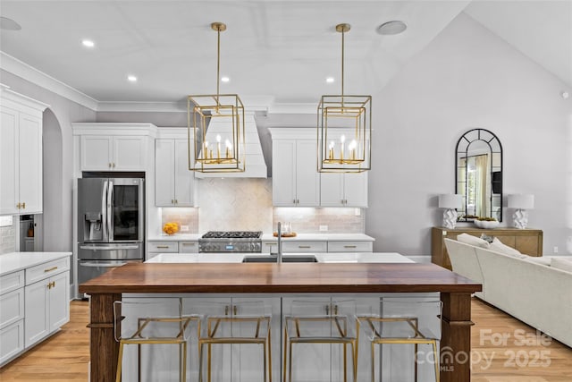 5638 Timber Ln, Charlotte, NC 28270 - kitchen with stainless steel appliances, wooden counters, premium range hood, white cabinets, and a sink