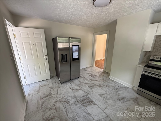 322 Buffalo St, Shelby, NC 28150 - kitchen featuring stainless steel appliances, light marble finish floors, white cabinetry, a textured ceiling, and light countertops