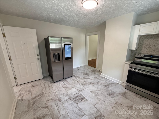 322 Buffalo St, Shelby, NC 28150 - kitchen with stainless steel appliances, white cabinets, a textured ceiling, light marble finish flooring, and light countertops