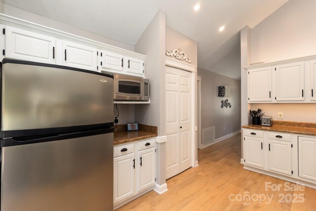 100 Donna Dr, Franklin, NC 28734 - kitchen with appliances with stainless steel finishes, vaulted ceiling, white cabinetry, light wood-style flooring, and baseboards