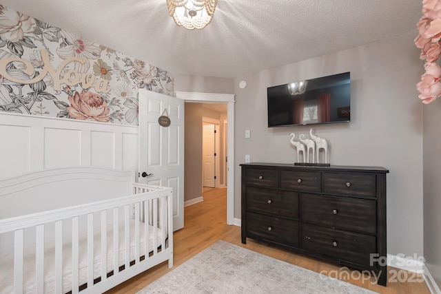 100 Donna Dr, Franklin, NC 28734 - bedroom with light wood finished floors, a wainscoted wall, and a textured ceiling
