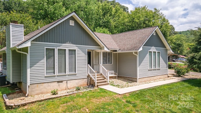 100 Donna Dr, Franklin, NC 28734 - bungalow-style home with a chimney, roof with shingles, a front lawn, board and batten siding, and a view of trees