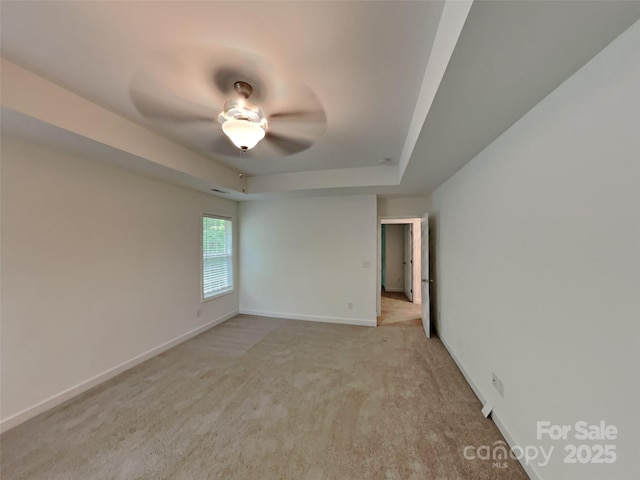 2612 Cold Springs Rd, Concord, NC 28025 - empty room with light carpet, a tray ceiling, baseboards, and a ceiling fan