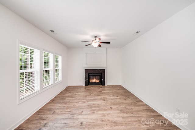 2612 Cold Springs Rd, Concord, NC 28025 - unfurnished living room with light wood-style flooring, a high end fireplace, and ceiling fan