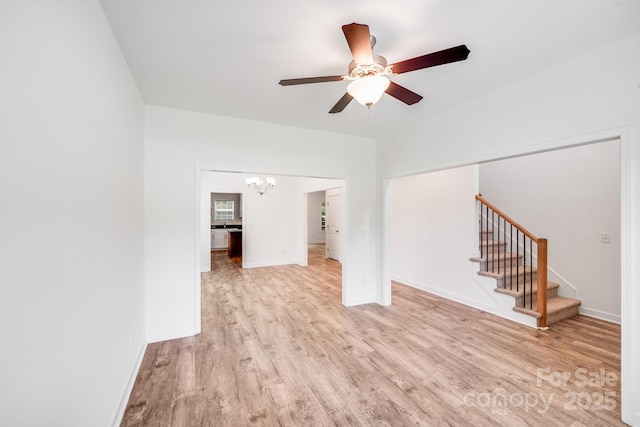 2612 Cold Springs Rd, Concord, NC 28025 - unfurnished living room featuring a chandelier, wood finished floors, a ceiling fan, and stairway