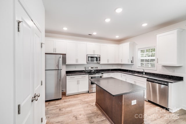 2612 Cold Springs Rd, Concord, NC 28025 - kitchen featuring stainless steel appliances, dark countertops, white cabinets, light wood finished floors, and recessed lighting