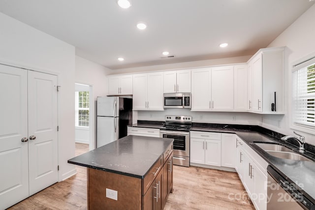 2612 Cold Springs Rd, Concord, NC 28025 - kitchen with appliances with stainless steel finishes, white cabinetry, light wood-style flooring, recessed lighting, and a kitchen island