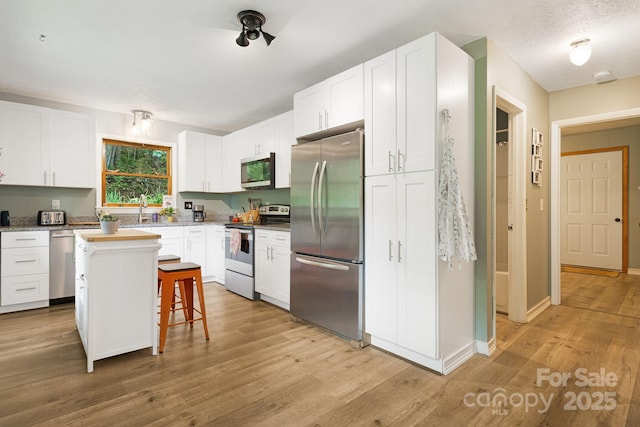 24 Cataloochee Ln, Waynesville, NC 28785 - kitchen featuring stainless steel appliances, white cabinets, and light wood-style flooring
