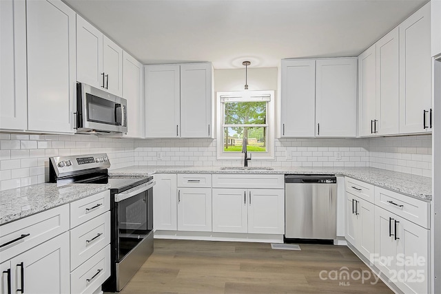 240 Swink Ave, Salisbury, NC 28147 - kitchen with stainless steel appliances, a sink, white cabinets, and tasteful backsplash