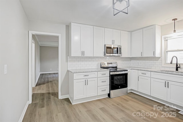 240 Swink Ave, Salisbury, NC 28147 - kitchen featuring stainless steel appliances, a sink, light wood-style flooring, decorative backsplash, and white cabinetry