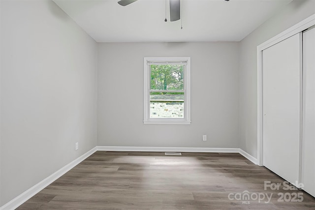 240 Swink Ave, Salisbury, NC 28147 - unfurnished bedroom with a closet, baseboards, wood finished floors, and a ceiling fan