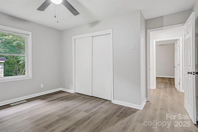 240 Swink Ave, Salisbury, NC 28147 - unfurnished bedroom with light wood-type flooring, a closet, baseboards, and a ceiling fan