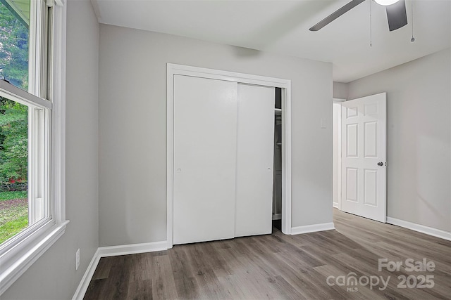 240 Swink Ave, Salisbury, NC 28147 - unfurnished bedroom featuring wood finished floors, baseboards, a closet, and a ceiling fan