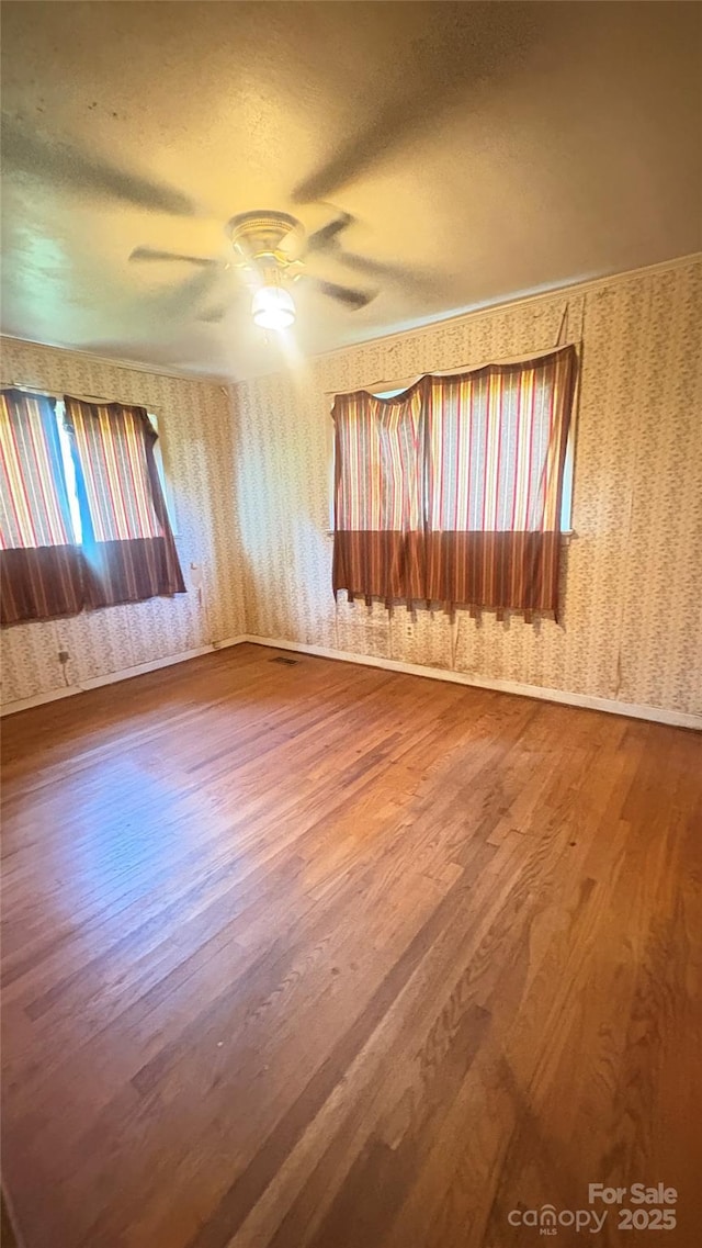1073 Springdale Dr, Maiden, NC 28650 - spare room featuring wallpapered walls, wood finished floors, a textured ceiling, and a ceiling fan