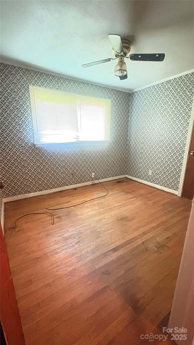 1073 Springdale Dr, Maiden, NC 28650 - unfurnished bedroom featuring hardwood / wood-style flooring, wallpapered walls, and a ceiling fan