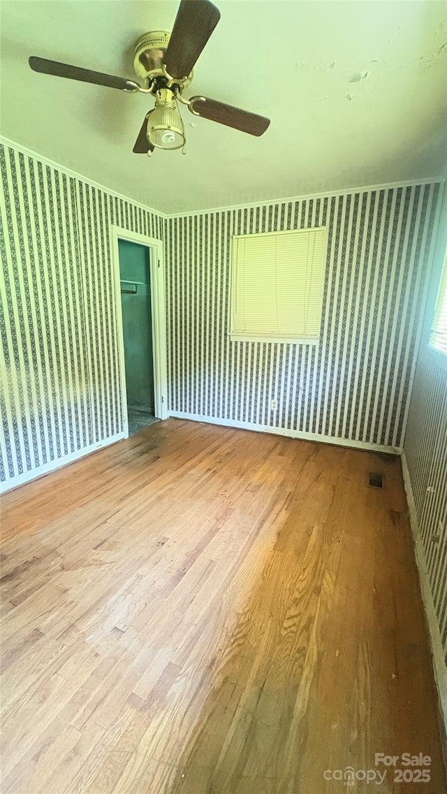 1073 Springdale Dr, Maiden, NC 28650 - spare room with wallpapered walls, wood finished floors, a ceiling fan, and baseboards