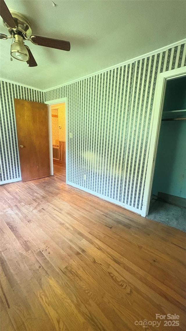 1073 Springdale Dr, Maiden, NC 28650 - unfurnished bedroom featuring wallpapered walls, wood finished floors, a ceiling fan, a closet, and baseboards