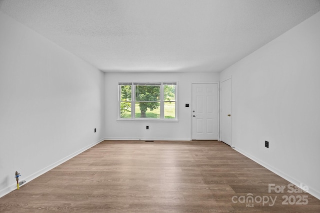 520 Forest St, Mars Hill, NC 28754 - empty room with wood finished floors, a textured ceiling, and baseboards
