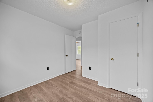 520 Forest St, Mars Hill, NC 28754 - unfurnished bedroom with light wood finished floors, a textured ceiling, and baseboards