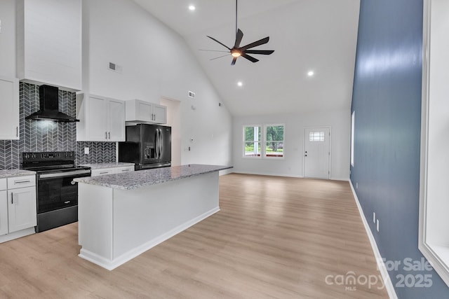 516 N Mulberry St, Cherryville, NC 28021 - kitchen with range with electric stovetop, black fridge, wall chimney range hood, high vaulted ceiling, and a ceiling fan