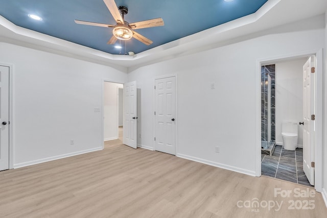 516 N Mulberry St, Cherryville, NC 28021 - unfurnished bedroom featuring a raised ceiling, wood finished floors, recessed lighting, ensuite bathroom, and a ceiling fan