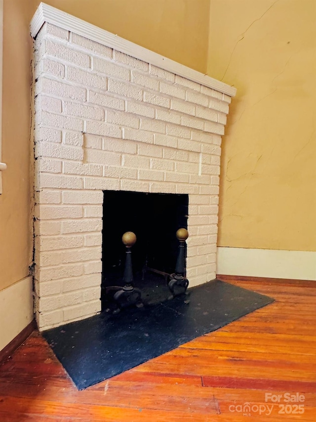602 Brookshire St, Asheville, NC 28803 - detailed view of wood finished floors, a brick fireplace, and baseboards