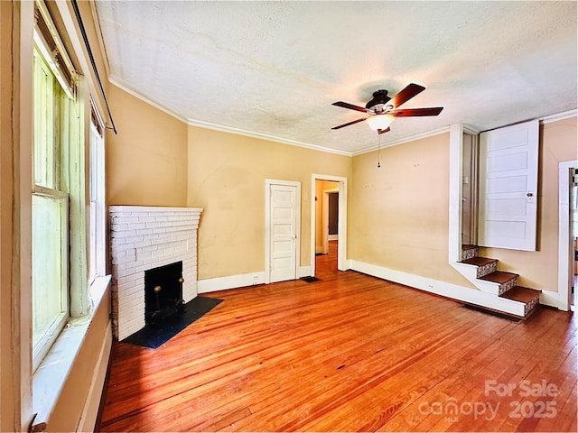 602 Brookshire St, Asheville, NC 28803 - unfurnished living room featuring wood-type flooring, a ceiling fan, a textured ceiling, ornamental molding, and baseboards
