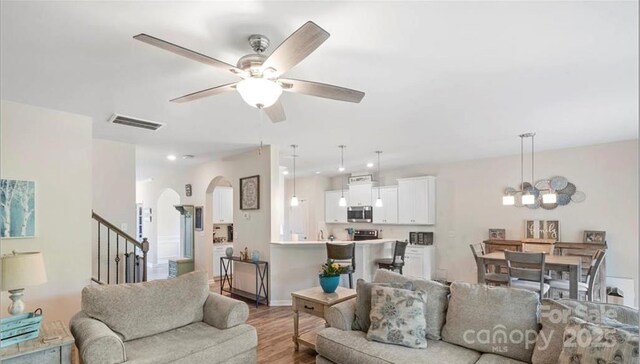 2009 Trindle Vine Ln, Waxhaw, NC 28173 - living room featuring arched walkways, ceiling fan, wood finished floors, stairs, and a chandelier