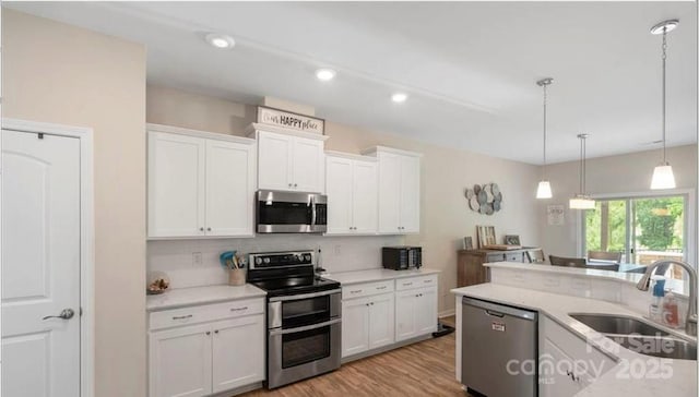 2009 Trindle Vine Ln, Waxhaw, NC 28173 - kitchen with appliances with stainless steel finishes, a sink, backsplash, light countertops, and hanging light fixtures