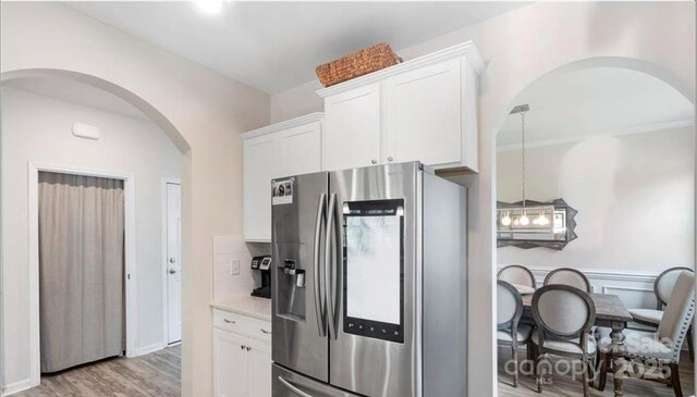 2009 Trindle Vine Ln, Waxhaw, NC 28173 - kitchen featuring stainless steel refrigerator with ice dispenser, arched walkways, light wood-style floors, white cabinets, and light countertops