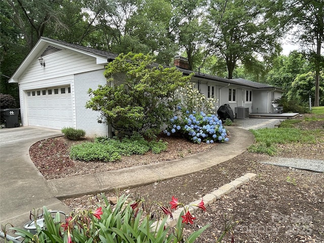 103 Boyd Dr, Stanley, NC 28164 - view of front of property featuring central AC, a garage, brick siding, view of wooded area, and a chimney