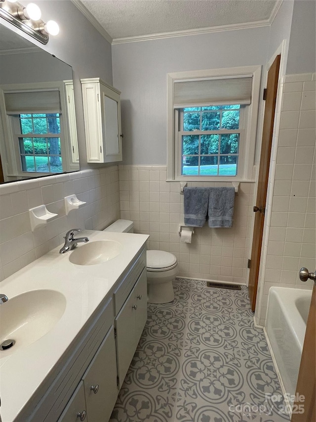 103 Boyd Dr, Stanley, NC 28164 - bathroom featuring plenty of natural light, double vanity, a textured ceiling, toilet, and ornamental molding