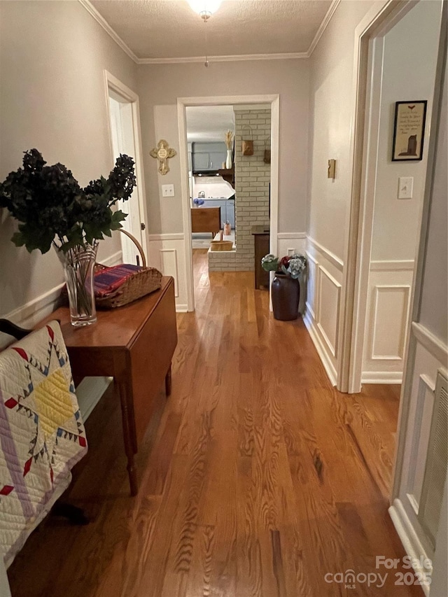 103 Boyd Dr, Stanley, NC 28164 - corridor featuring crown molding, wood finished floors, a wainscoted wall, and a decorative wall