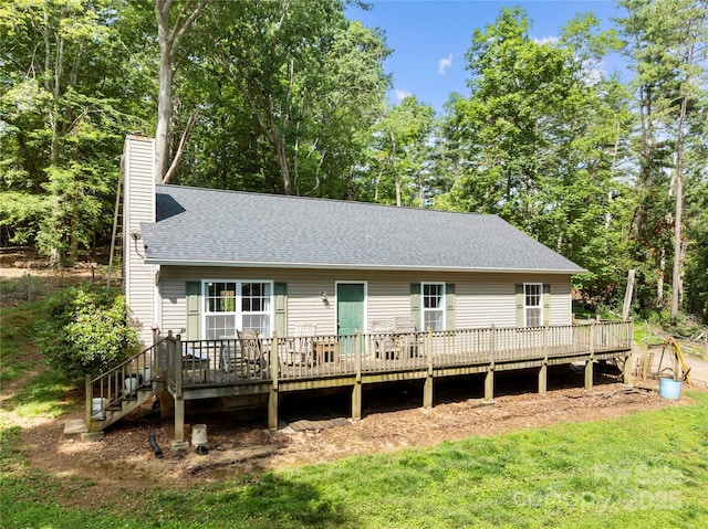 55 Gilbert B Crook Rd, Candler, NC 28715 - back of house with a chimney, a deck, roof with shingles, and a lawn