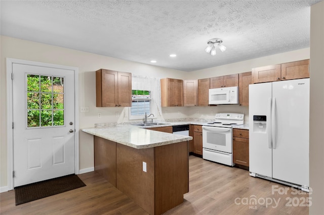 55 Gilbert B Crook Rd, Candler, NC 28715 - kitchen featuring white appliances, a peninsula, light wood-style flooring, a textured ceiling, and light countertops