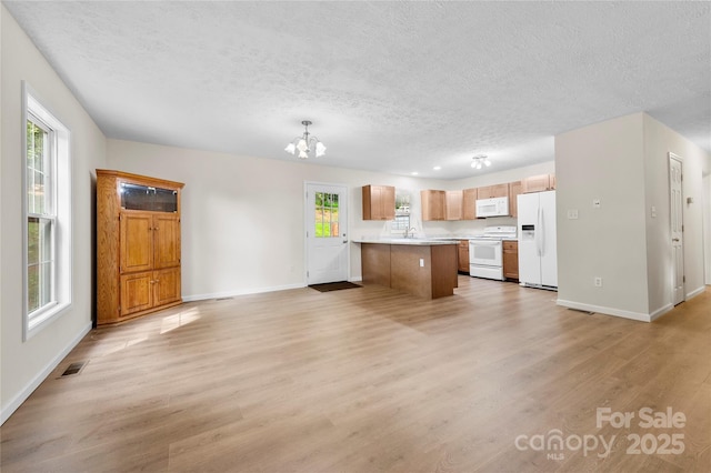 55 Gilbert B Crook Rd, Candler, NC 28715 - kitchen featuring white appliances, open floor plan, a textured ceiling, a chandelier, and light countertops