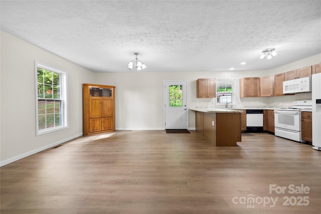 55 Gilbert B Crook Rd, Candler, NC 28715 - kitchen with white appliances, wood finished floors, a chandelier, a textured ceiling, and light countertops