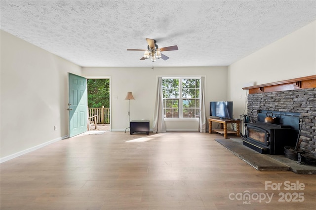 55 Gilbert B Crook Rd, Candler, NC 28715 - living area with ceiling fan, wood finished floors, a wood stove, and a textured ceiling