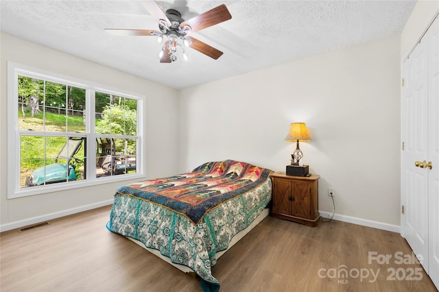 55 Gilbert B Crook Rd, Candler, NC 28715 - bedroom with wood finished floors, a textured ceiling, a closet, and ceiling fan