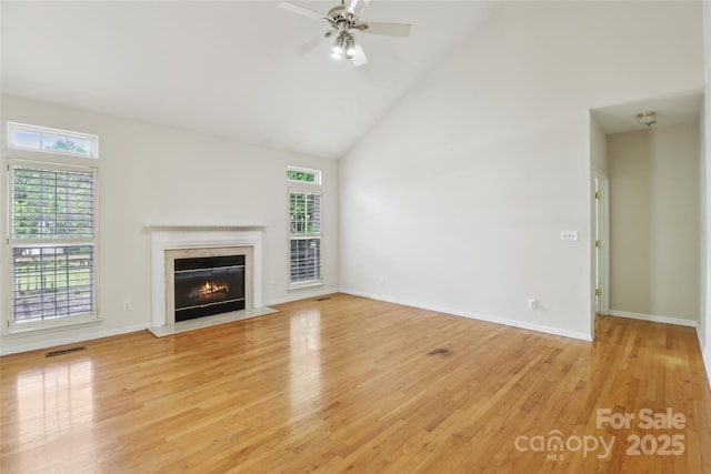 2321 Oberwood Dr, Charlotte, NC 28270 - unfurnished living room with a glass covered fireplace, light wood-type flooring, high vaulted ceiling, and a ceiling fan